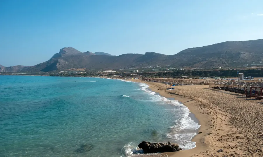 La playa de Falasarna en Creta con agua turquesa y sombrillas sobre arena blanca