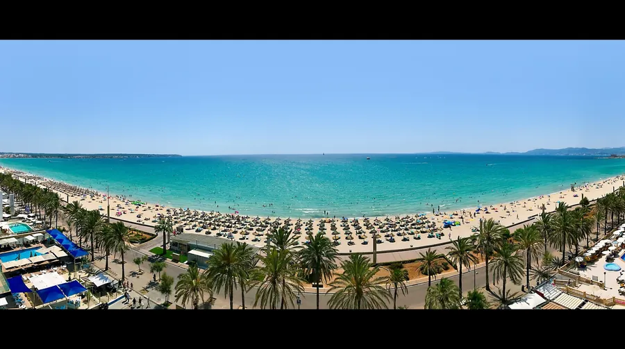 La Playa de Palma desde arriba, una larga playa de arena con un paseo bordeado de palmeras