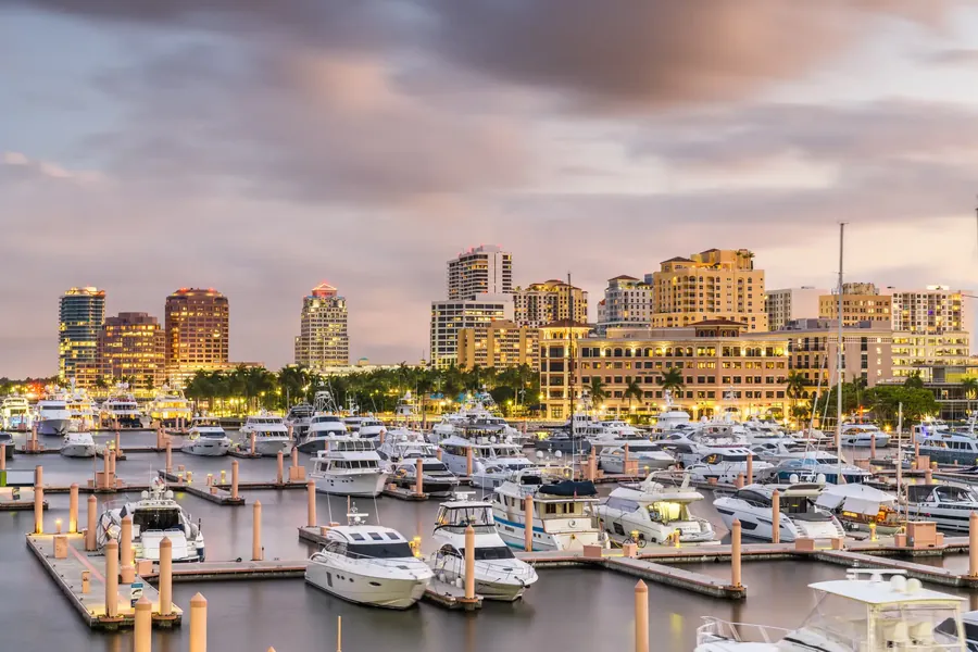 El perfil de West Palm Beach al otro lado del agua con palmeras y un puerto deportivo