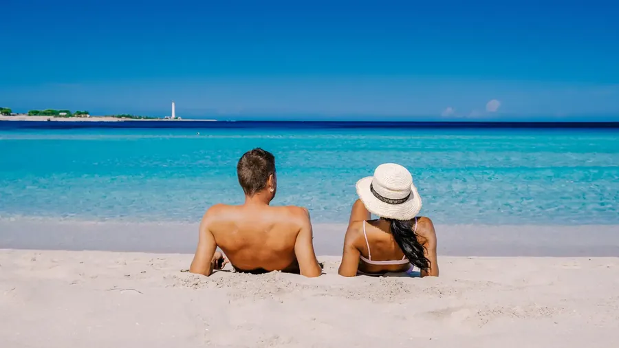 La playa de San Vito Lo Capo con arena blanca, agua turquesa y el Monte Monaco detrás