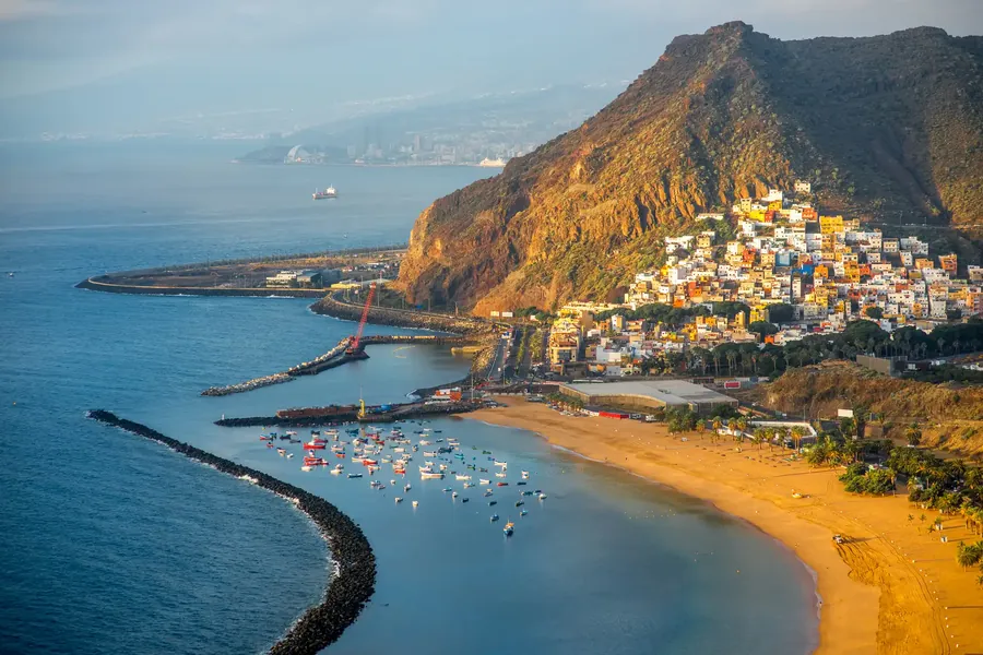 La playa de Las Teresitas con arena dorada, palmeras y las montañas de Anaga detrás
