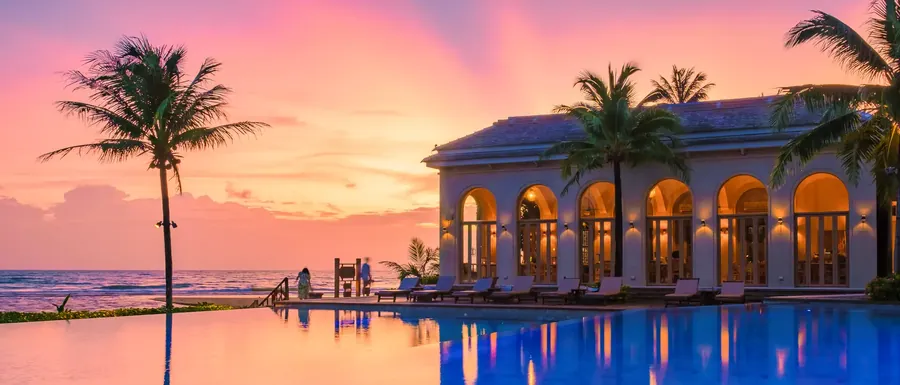 Una piscina de resort al atardecer en una isla tropical